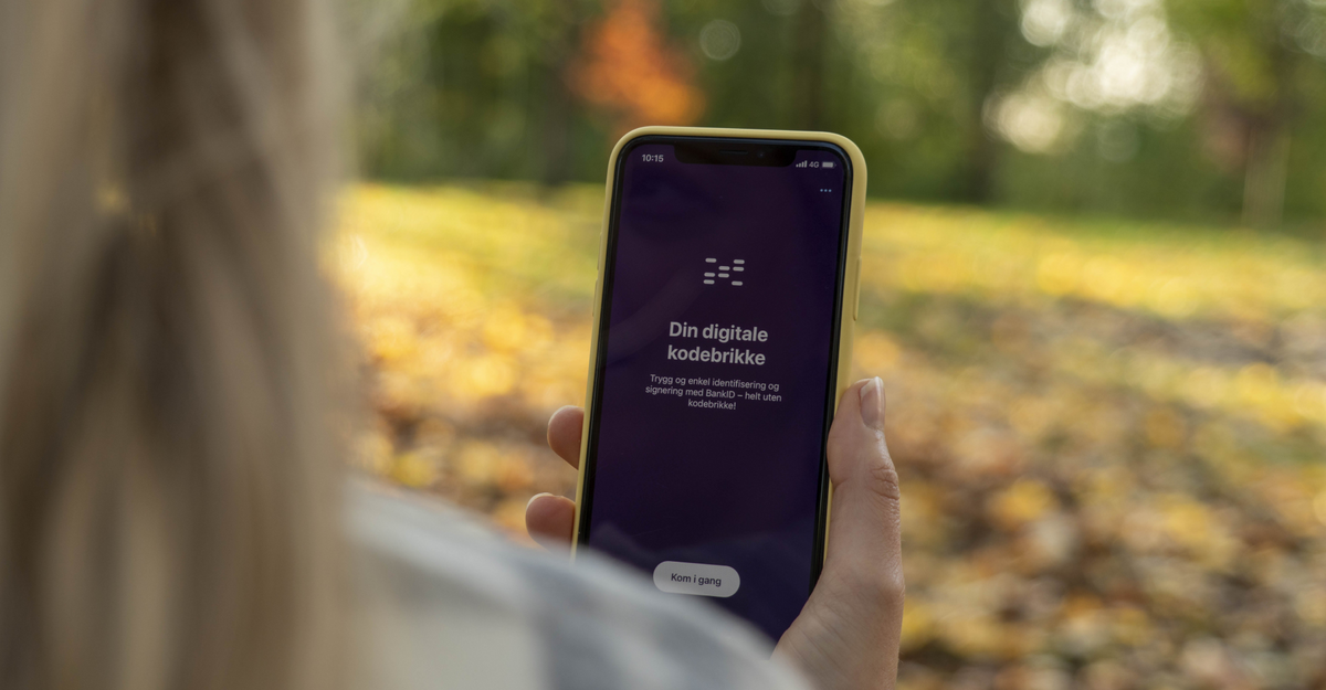 Dame holder i en telefon med "din digitale kodebrikke"