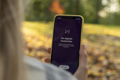 Dame holder i en telefon med "din digitale kodebrikke"