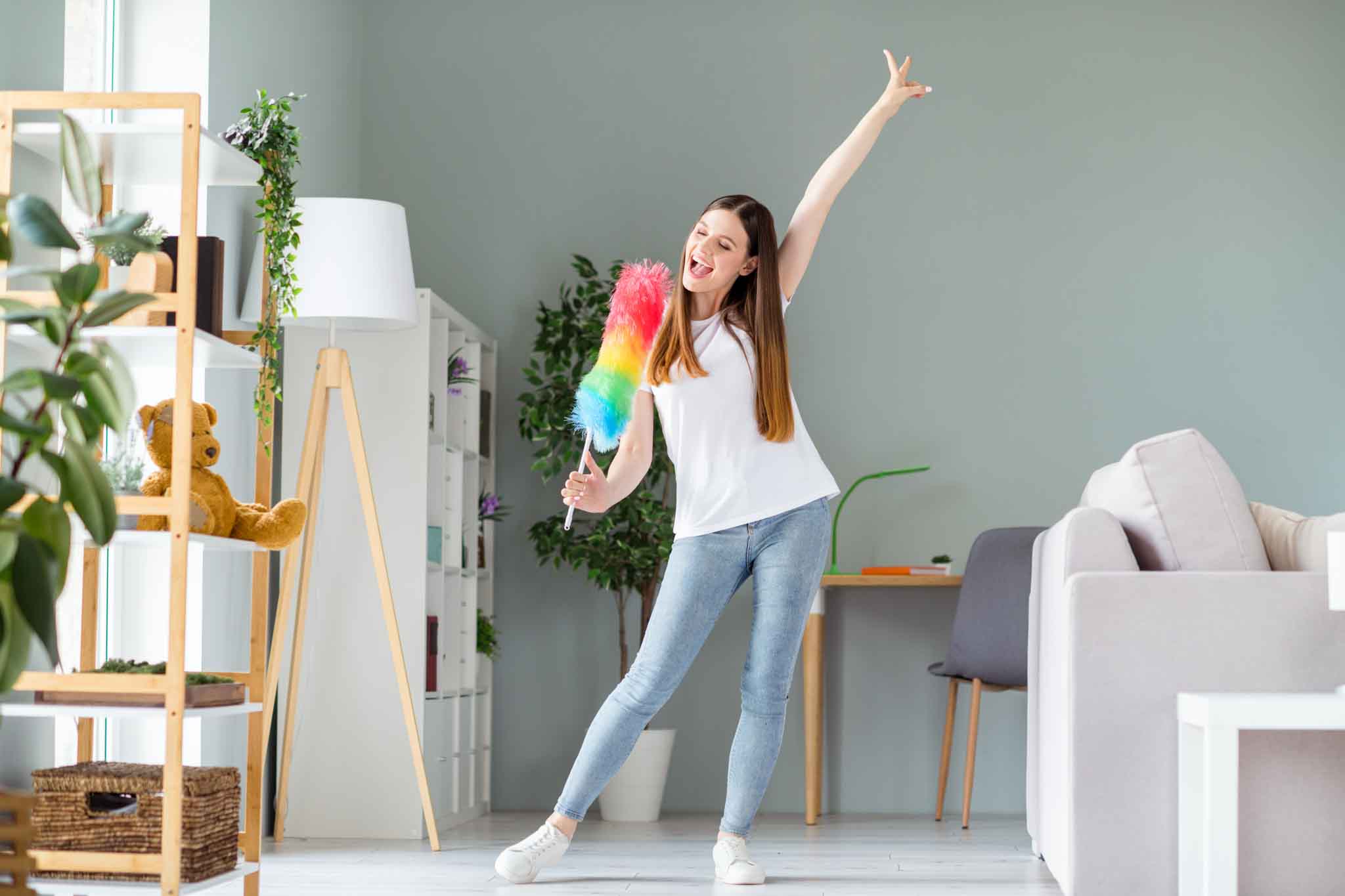 Full length body size view of attractive cheerful funky girl cleansing dust singing in brush having fun at home living room indoors