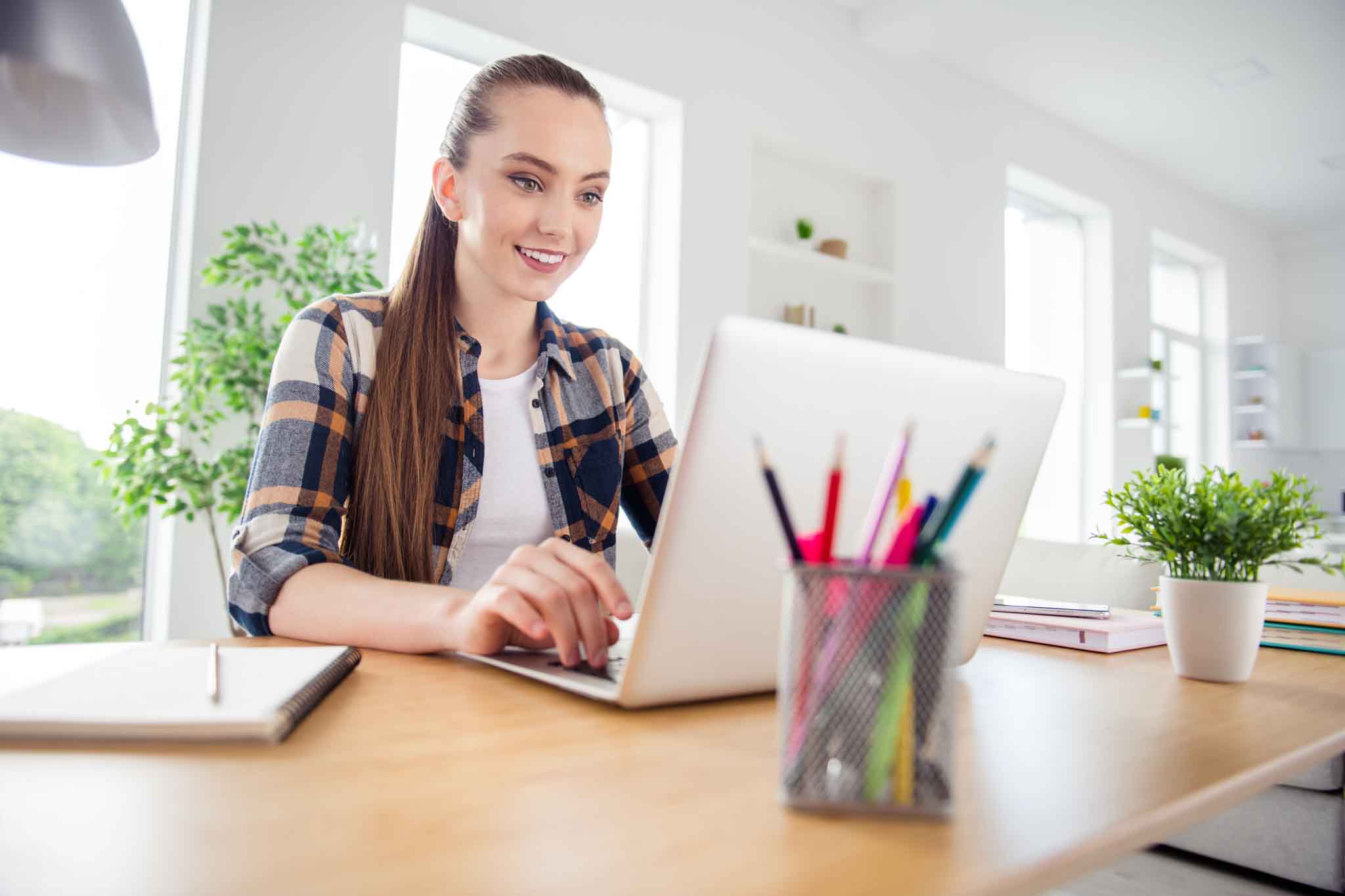 Photo of young pretty lady student browsing laptop notebook sitting table, desktop video call listen teacher lesson online conference education concept social distance quarantine indoors