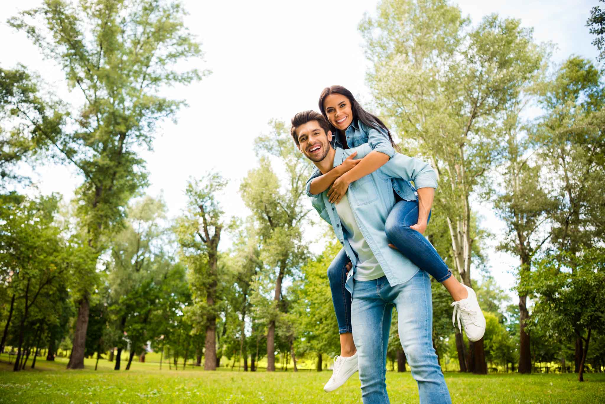 Pretty pair finally having fun vacation together walking green street, outside wear denim outfit
